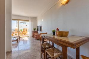 a dining room with a wooden table and chairs at Acacias II vistas Arysal in Salou