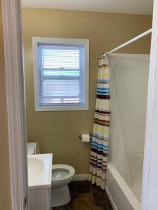 a bathroom with a sink and a toilet and a window at Wu Wu's Cabins in Wasaga Beach