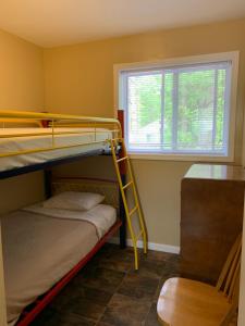 a room with two bunk beds and a window at Wu Wu's Cabins in Wasaga Beach