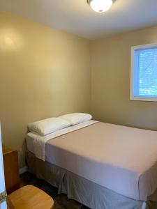 a bedroom with two beds and a window at Wu Wu's Cabins in Wasaga Beach
