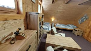 eine Blockhütte mit einem Schreibtisch und ein Zimmer mit Betten in der Unterkunft Chata Raj in Hrabušice