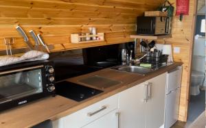 a kitchen with a microwave and a sink at Hare's Warren in Bathgate