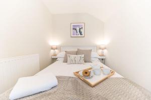 a bedroom with a bed with a tray of food on it at Cow Barn, Duddon Bridge in Broughton in Furness