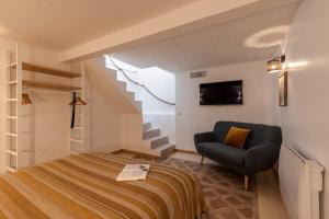 a bedroom with a bed and a chair and stairs at La Maison Du Pêcheur in Cagnes-sur-Mer