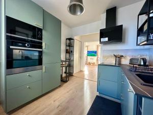 uma cozinha com armários azuis e uma bancada em Le LUTZ em Nîmes