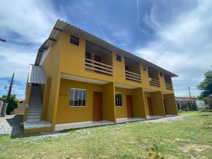 una gran casa amarilla con patio en Kitnet Apto em Cabo Frio RJ - Recanto das Corujas en Cabo Frío