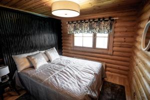 a bedroom with a bed in a log cabin at Kolin Vernetti 3 in Kolinkylä
