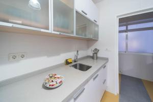 阿爾梅里亞的住宿－Expoholidays - Javier Sanz，一间白色的厨房,在柜台上放有盘子的食物