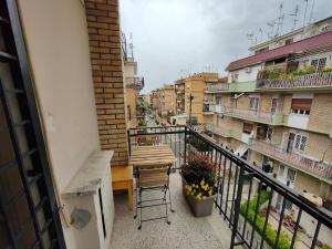 balcón con mesa de madera, sillas y edificios en Eufonia Gemelli Apartment en Roma