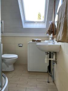 a bathroom with a sink and a toilet and a window at Uroczy domek nad samym morzem in Dębki