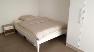 a small white bed in a room with a white cabinet at Apartment mit Terrasse in Abstatt in Abstatt