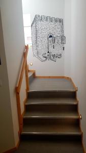 una escalera con un dibujo en la pared en Al-Xelb guesthouse, en Silves