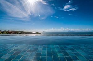 a swimming pool with a view of the ocean at Buzios Mar Hotel in Búzios