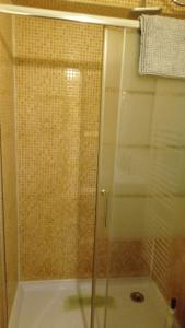 y baño con ducha y puerta de cristal. en Zapaterías, en León