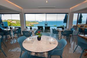 un restaurante con mesas y sillas y vistas al océano en Buzios Mar Hotel, en Búzios
