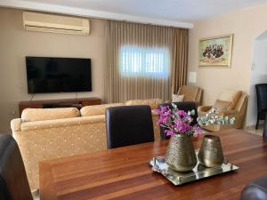 a living room with a couch and a table with flowers at Sea You Soon! in Netanya