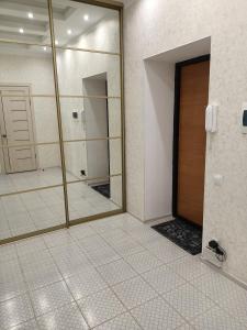 uma casa de banho com uma porta e um espelho em 1 комнатная квартира ЖК Альтаир по ул.Байшева 7а em Aqtöbe