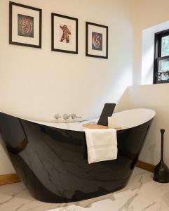 a black and white bath tub in a bathroom at Private Cliffside Chalet Nestled in Nature With Western Sunsets & Waterfront Access Near Algonquin Park- Pass Included in Barrys Bay +49 photos