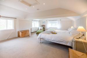 a white bedroom with a large bed and two windows at Ivy House Mells in Halesworth