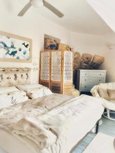 sypialnia z 2 łóżkami i wentylatorem sufitowym w obiekcie Ippocampo Blanc w mieście San Felice Circeo