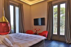 1 dormitorio con 1 cama y TV en la pared en SA Suites, en Trepuzzi