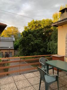 - une table verte et 2 chaises sur la terrasse dans l'établissement Casa Vacanza da Violetta, à Faedis