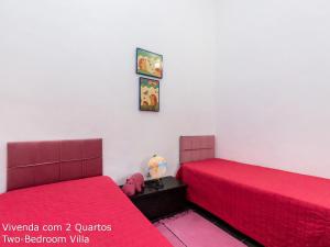 Akivillas Loulé Village في لولي: سريرين في غرفة ذات أغطية وردية