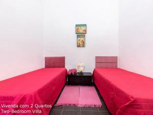duas camas num quarto com lençóis vermelhos em Akivillas Loulé Village em Loulé