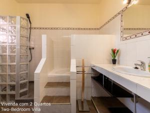 La salle de bains est pourvue d'une baignoire, d'un lavabo et d'une douche. dans l'établissement Akivillas Loulé Village, à Loulé