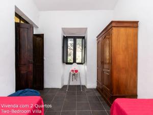 a room with a bed and a dresser and a chair at Akivillas Loulé Village in Loulé