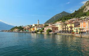 a town next to a body of water with buildings at Graziella House in Brenzone sul Garda +30 photos