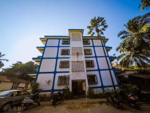 a blue and white building with a palm tree at Moroccan Suite Calangute Beach Vibe in Calangute