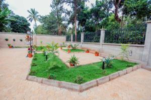 a garden with palm trees and plants in front of a fence at Stunning 2-Bed Apartment in Moshi Town in Moshi