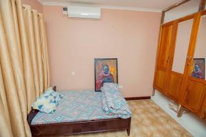 1 dormitorio pequeño con 1 cama y armario en Stunning 2-Bed Apartment in Moshi Town en Moshi
