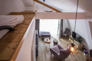 a loft bedroom with a bed and a living room at Pano Kopaonik Panorama in Kopaonik