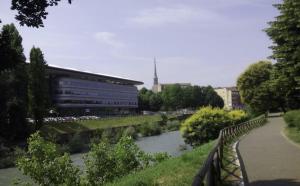 a bridge over a river in front of a building at Bene39 in Turin
