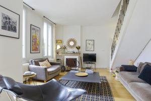 uma sala de estar com um sofá e uma mesa em Maison de l'Ermitage - Welkeys em Le Bouscat