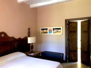 1 dormitorio con 1 cama, 1 mesa y 1 lámpara en Cave Garden villa, en Favignana
