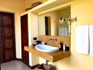 a bathroom with a sink and a large mirror at Cave Garden villa in Favignana