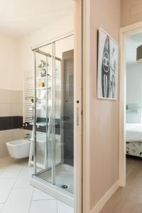 La salle de bains est pourvue d'un lavabo et d'une porte de douche en verre. dans l'établissement Bardolino Suite, à Bardolino
