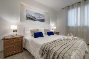 ein Schlafzimmer mit einem großen weißen Bett mit blauen Kissen in der Unterkunft App in Villa con Piscina - 45 min Venezia - Zona Unesco in San Pietro di Feletto