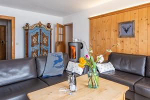 a living room with a leather couch and a wooden table at Fischer Apartments in Oberammergau