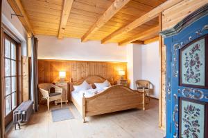 - une chambre avec un grand lit et un plafond en bois dans l'établissement Fischer Apartments, à Oberammergau
