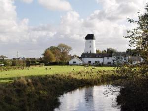 a lighthouse in the middle of a field with a river at The Bakery in Pilling