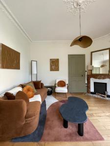a living room with a couch and a table at Demeure de charme in Lons-le-Saunier