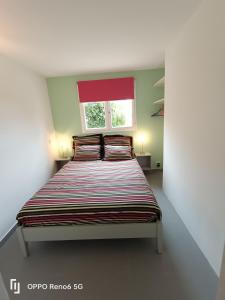 Schlafzimmer mit einem Bett und einem roten Fenster in der Unterkunft La Romarine in Falicon