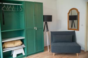 a green cabinet and a chair in a room at Zuhause fühlen in Kreuzberg in Berlin