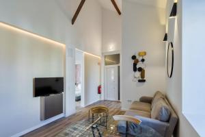Una sala de estar con un sofá y un televisor. en Golden Setubal, en Setúbal
