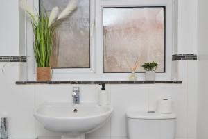 a bathroom with a sink and a window with plants at Central Nottingham house in Nottingham