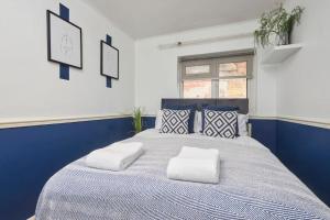 sypialnia z niebiesko-białym łóżkiem z poduszkami w obiekcie Central Nottingham house w Nottingham